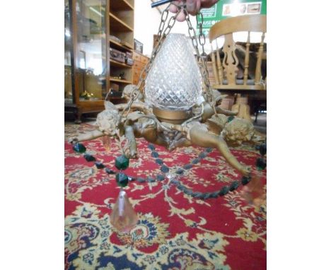 A glass ceiling light fitting in the form of four cherubs with hobnail cut glass conical shade