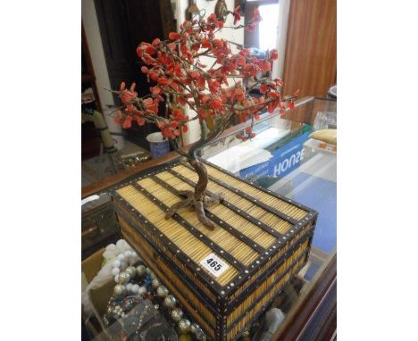 A porcupine quill box, a selection of cowrie shells, a Kodak projector and two hardstone models of trees