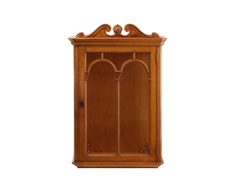 An early 20th-century sycamore single door wall mounted display cabinet with moulded cornice above decorative moulded and car