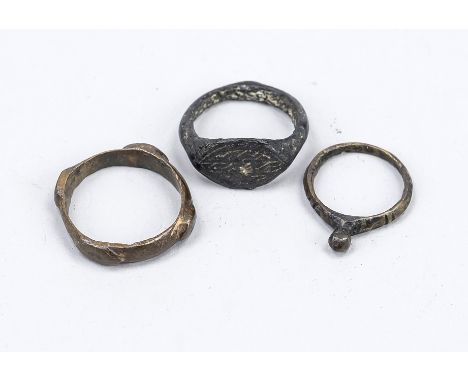 3 Ringe, wohl Antike bzw. Mittelalter, Bronze. Einer mit rhombischer, kerbschnittverzierter Ringplatte. Einer mit kugelförmig