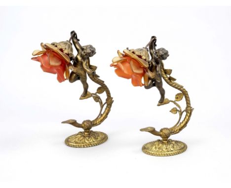 Paar Wandlampen, Ende 19. Jh., Messing/Bronze. Schwebende Knaben an ornamentierter Halterung einen Schirm aus Glas in Blütenf