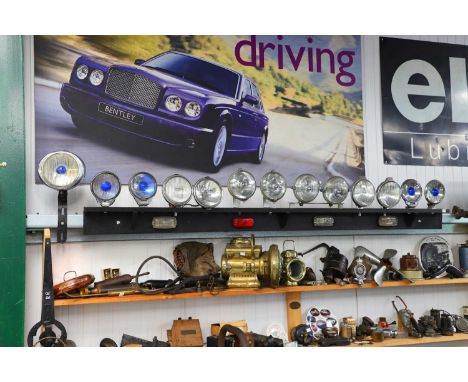 A mounted display of early motoring lamps,wired as two displays with vintage switches and a single Lucas headlamp,30cm diamet