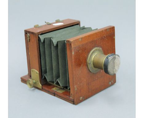 A mahogany plate camera with brass lens. 23 cm long.