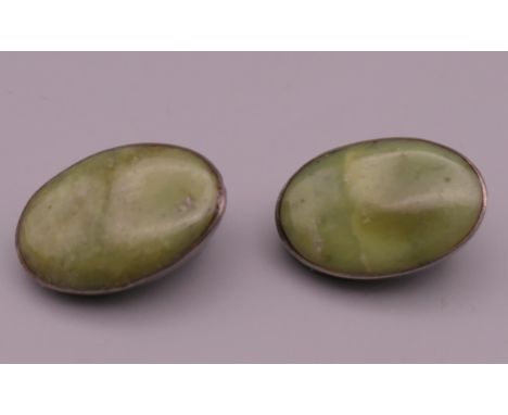 A pair of silver and jade ear clips. 2 cm high.