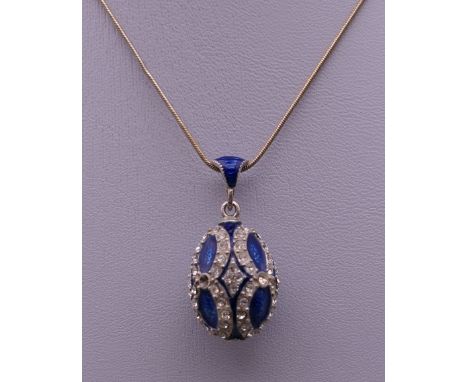 An enamel decorated silver egg form pendant on chain. The pendant 3 cm high.