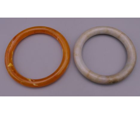 A jade bangle and another. The former 6 cm inner diameter. 