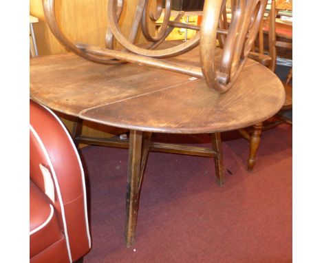 A circular Ercol elm drop leaf dining table, H:71cm W:112cm D:112cm