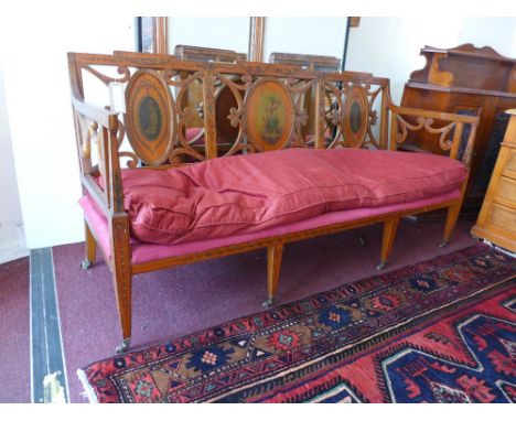 A late 19th Century French satinwood three seater sofa, having three oval back sections with hand painted Classical designs, 