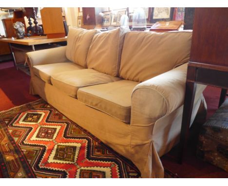 A cotemporary three seater sofa upholstered in an oatmeal coloured fabric H:90cm W:214cm D:87cm 