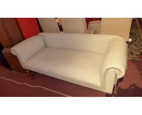 A Victorian style two seater sofa upholstered in a stone linen and raised on turned legs, H:61cm W:135cm D:54cm