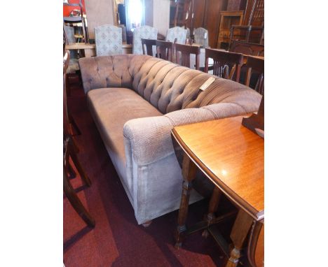 A three seater Chesterfield sofa upholstered in brown fabric with buttoned back, raised on turned supports. H-75cm W-200cm D-