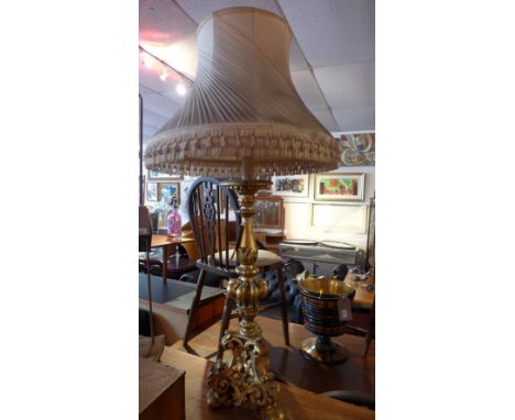 A giltwood lamp, ornately carved, with shade. H-120cm, W-58cm, D-58cm