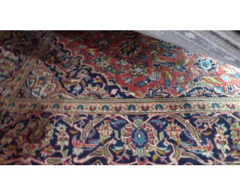 A central Persian Kashan carpet, 293cm x 190cm, the double pendant medallion on a rouge field within floral border