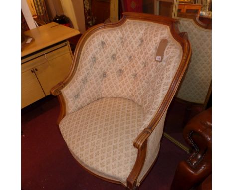 A 19th Century French walnut armchair with button back damask upholstery raised on reeded tapered legs
