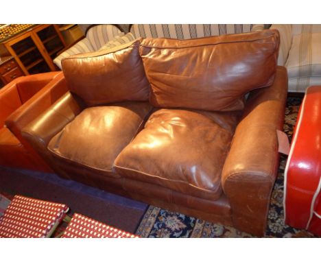 A contemporary brown leather two seater sofa, H:80cm W:175cm D:90cm