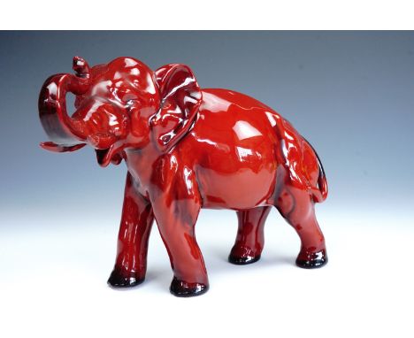 A Royal Doulton Flambe Ware elephant, modelled standing on all fours with trunk raised, 18 cm, old break and repair to tip of