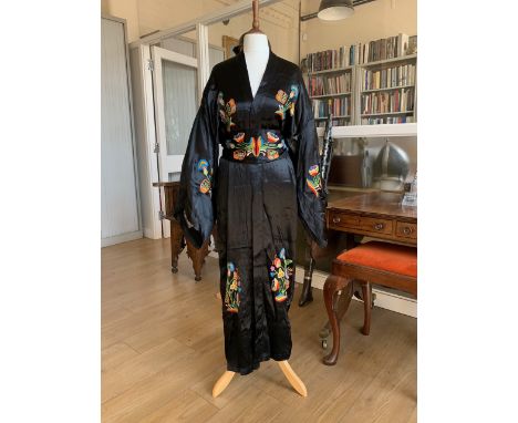 A 1930s black silk kimono, with chain stitch embroidered decoration in the form of jazzy multi-coloured flowers, together wit