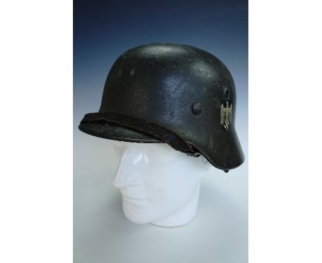 A German Third Reich Army M 1940 steel helmet, bearing a single decal, the shell stamped SE64 and numbered 435, bearing the p