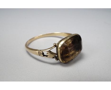 A Georgian citrine dress ring, the cushion cut stone being collet-set in a closed back setting, with pierced and trifurcated 