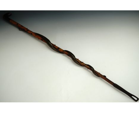 A late 19th Century walking stick, carved and painted in imitation of a serpent entwining a knotted or studded staff, termina