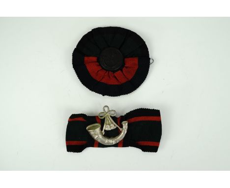 An early 20th Century Light Infantry slouch hat button and cockade, together with one other similar badge
