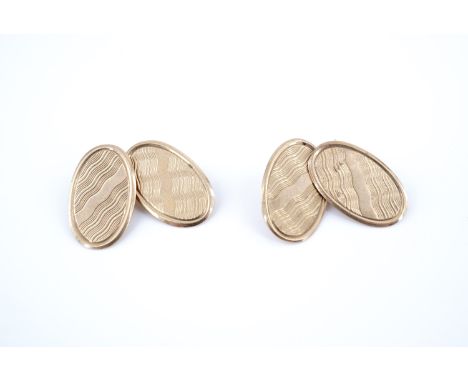 A pair of 1920s 9 ct gold cuff links, their oval faces decorated with wavy engine turning, 3.9 g