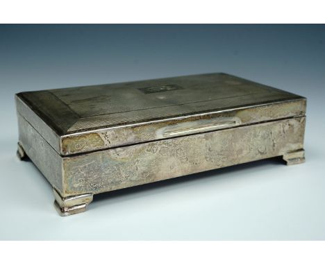 A 1960s silver table cigarette box, the subtly domed lid decorated with engine turning centred by a cartouche with the engrav