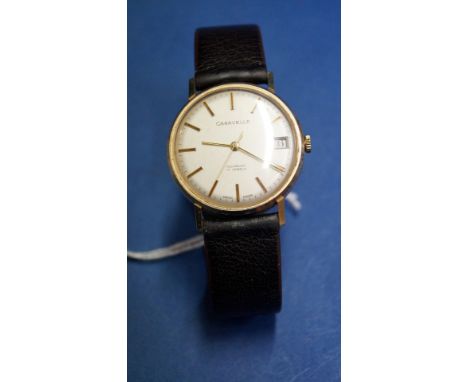 A Caravelle 9ct gold gentleman's manual wristwatch, having 3cm silvered dial decorated baton markers and date aperture at 3 o