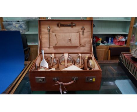 A vintage leather cased travelling toilet set, with silver and electroplated mounted fittings, mostly by Margrett of Bangkok.
