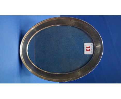 A silver oval photograph frame, by W Comyns, London 1915, having engine turned decoration, 23cm.