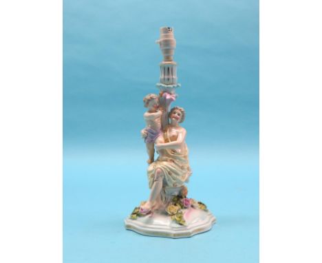 A 19th century Sitzendorf porcelain candlestick figure group, maternal stem on floral-encrusted base, crossed swords mark, 13