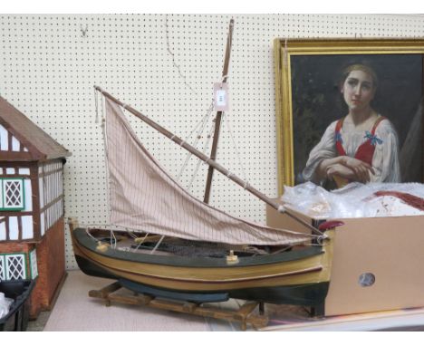 A painted wood boat model, single mast with one sail, with deck-details, twin oars and rudder, on stand, 31in. long 