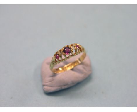 An 18ct. gold engagement ring, claw-set three rubies and two diamond chips, size L/M, Chester 1911