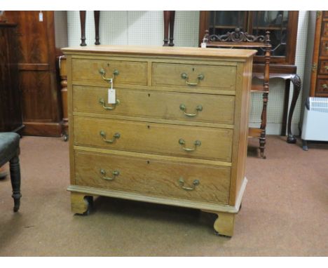 A solid, light oak chest, two short and three long graduated drawers, mahogany linings and brass swan-neck handles, on bracke