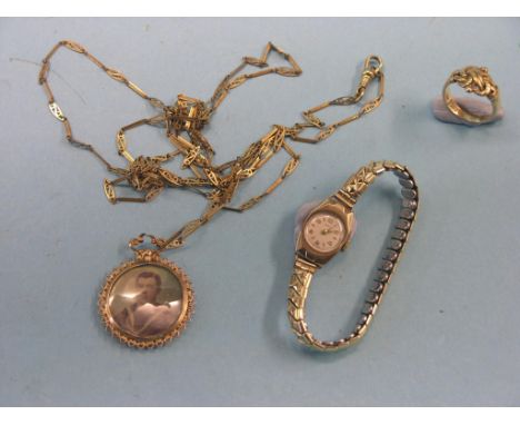An 18ct. gold cross-over ring, 7.2 grams, together with a Victorian yellow metal portrait photograph locket, on yellow metal 