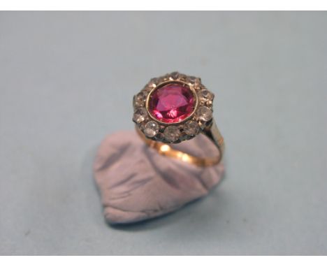 A late Victorian 18ct. gold dress ring, set large red stone and smaller surrounding clear stones, size M