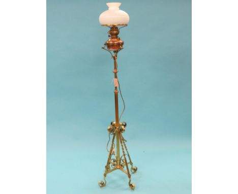 A Victorian brass telescopic floor-lamp, with copper mounts and oil reservoir, on four scroll supports, with opaque glass sha