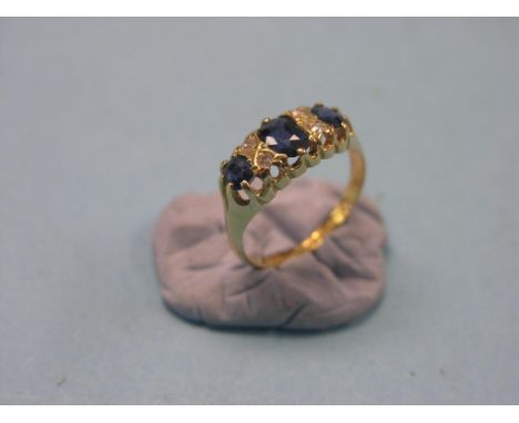 An 18ct. gold engagement ring, three sapphires and four diamond chips in half-hoop claw setting, size L/M, Birmingham 1917 