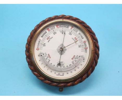 A late Victorian aneroid barometer, circular-shape in carved oak rope-twist surround, printed ceramic dial with fitted thermo