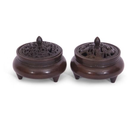 Two small Chinese bronze censers with pierced covers and six character reign mark to base, raised on three stub feet (2)