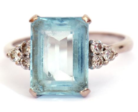 Precious metal aquamarine and diamond ring, the step cut aquamarine in a four-claw mount, flanked by diamond set shoulders, f