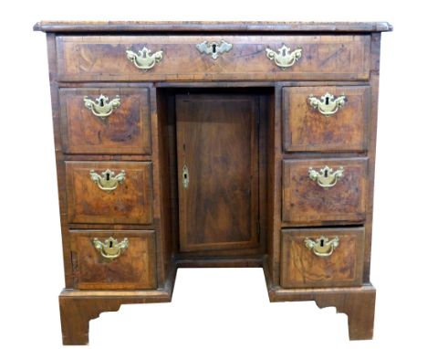 Queen Anne period walnut, kneehole desk of small proportions, the quatered and crossbanded top with indented corners. The fro