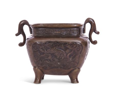 Oriental bronze bowl decorated in relief with dragons and with indistinct character reign mark to base, the bowl raised on fo