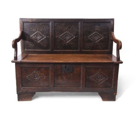 Oak monk's bench, three panelled back and front incised with geometric diamond shaped designs, lift up seat and bracket feet,