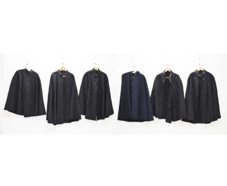 Five police issue officer's capes, one with lion head clasps with small chain connectors, together with a similar hooded cape