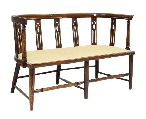 Edwardian inlaid mahogany two-seat sofa, the seat upholstered in gold patterned fabric, raised on turned tapering supports un