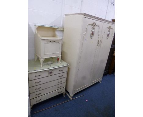 A FIVE PIECE CREAM AND GILT BEDROOM SUITE, with decorative ceramic oval to some pieces, comprising of a two door wardrobe, dr