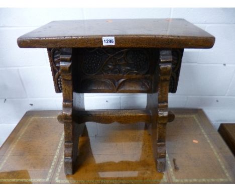 A HEAVY CARVED OAK STOOL