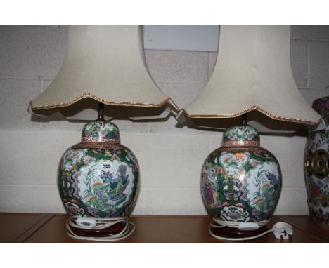 A PAIR OF CHINESE FAMILLE VERTE BULBOUS LAMP BASES AND SHADES, script, floral and insect details, on hardwood stands, height 