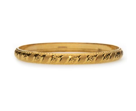 GOLD BANGLE, with S curve decoration in bright finish to a satin finish body, 56mm to outer edge, marked 22K, 7.8g
